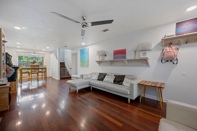 living room featuring hardwood / wood-style floors, visible vents, baseboards, ceiling fan, and stairs