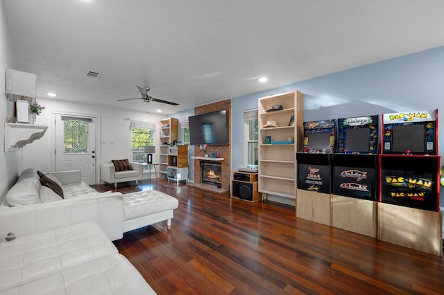 living room with a ceiling fan, recessed lighting, visible vents, a brick fireplace, and wood finished floors