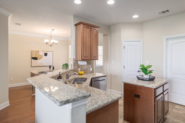 103 Aria Rdg Unit 902, Austin, TX 78738 - kitchen with stainless steel dishwasher, a peninsula, tasteful backsplash, a chandelier, and a center island