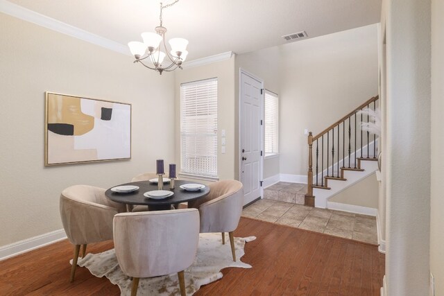 103 Aria Rdg Unit 902, Austin, TX 78738 - dining area featuring a chandelier, stairway, wood finished floors, and ornamental molding