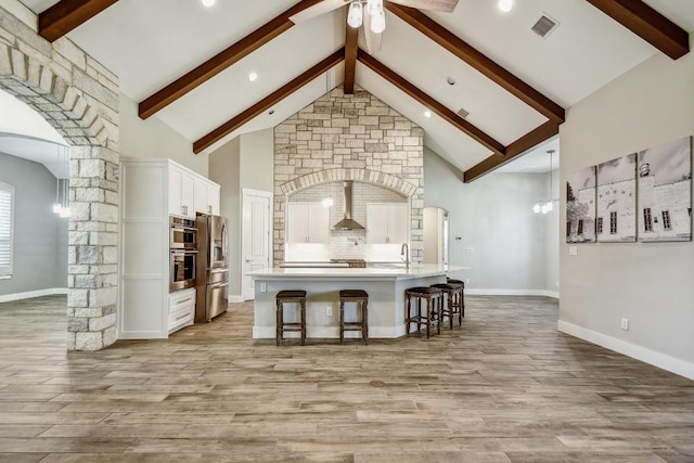 1609 Havenwood Blvd, New Braunfels, TX 78132 - kitchen with arched walkways, high vaulted ceiling, beam ceiling, ceiling fan, and a kitchen bar