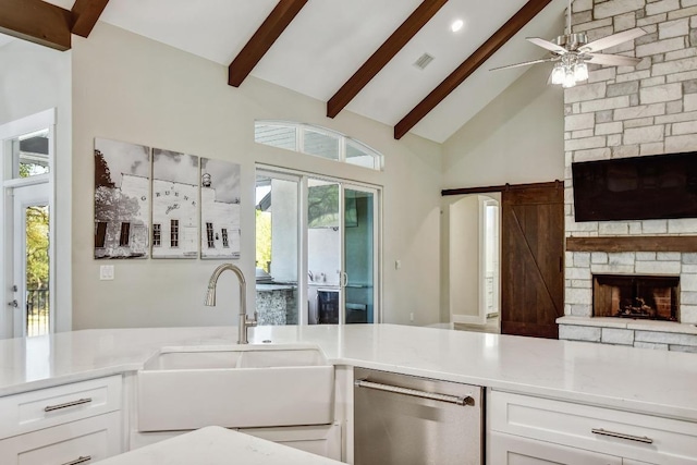 1609 Havenwood Blvd, New Braunfels, TX 78132 - kitchen featuring a sink, dishwasher, a fireplace, beamed ceiling, and white cabinetry