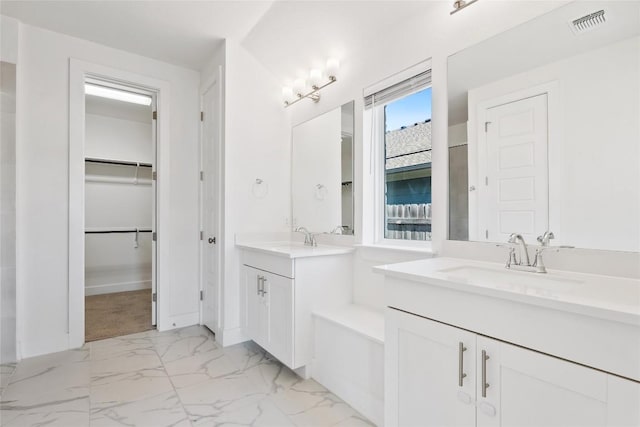 105 Lemuel Crawford Trl, Bastrop, TX 78602 - bathroom featuring a sink, two vanities, a walk in closet, and marble finish floor
