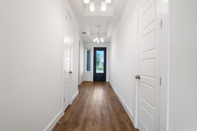105 Lemuel Crawford Trl, Bastrop, TX 78602 - doorway to outside with a notable chandelier, baseboards, dark wood-style floors, visible vents, and a tray ceiling