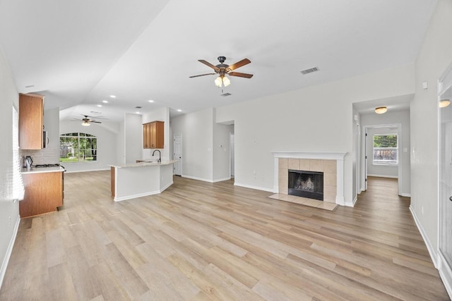 806 Broken Trace Ct, Round Rock, TX 78665 - unfurnished living room with ceiling fan, lofted ceiling, a fireplace, light wood finished floors, and baseboards