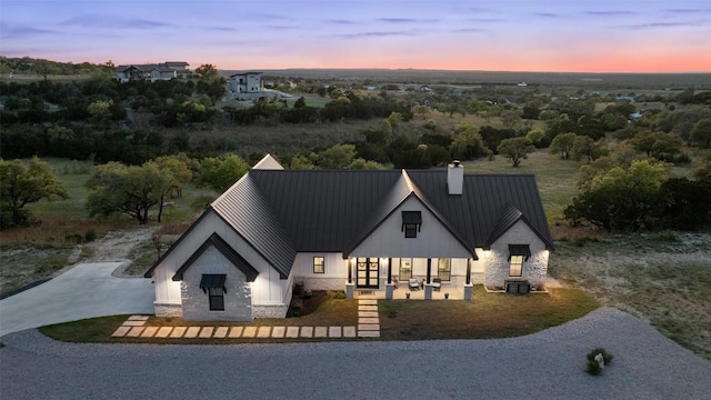 468 Cedar Mountain Dr, Marble Falls, TX 78654 - modern inspired farmhouse with stone siding, a chimney, metal roof, and a standing seam roof