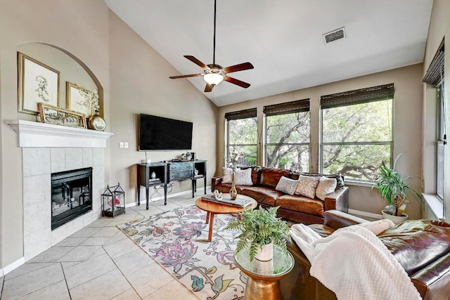 21940 Agarito Ln, Spicewood, TX 78669 - living area featuring a ceiling fan, light tile patterned flooring, a tiled fireplace, baseboards, and high vaulted ceiling