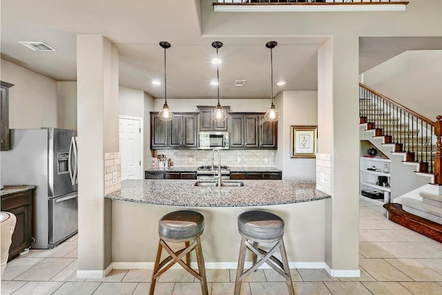 21940 Agarito Ln, Spicewood, TX 78669 - kitchen featuring stainless steel appliances, light stone counters, tasteful backsplash, and a sink