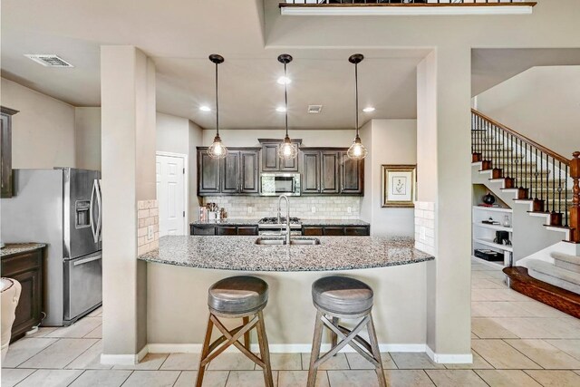21940 Agarito Ln, Spicewood, TX 78669 - kitchen featuring appliances with stainless steel finishes, light stone countertops, decorative backsplash, and a sink