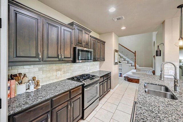 21940 Agarito Ln, Spicewood, TX 78669 - kitchen with appliances with stainless steel finishes, a sink, light stone counters, backsplash, and light tile patterned flooring