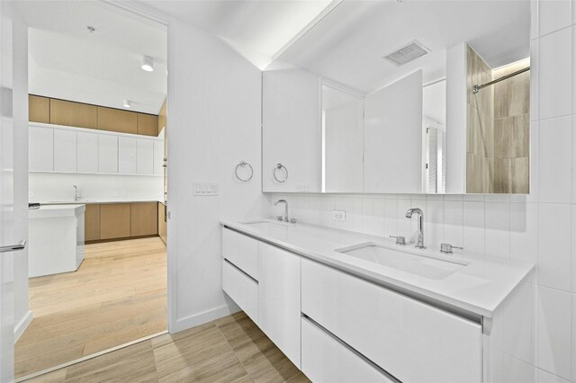 313 W 17th St Unit 2403, Austin, TX 78701 - bathroom with a sink, visible vents, backsplash, and double vanity