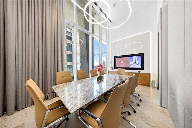 313 W 17th St Unit 2403, Austin, TX 78701 - dining room featuring light wood-style flooring and a towering ceiling