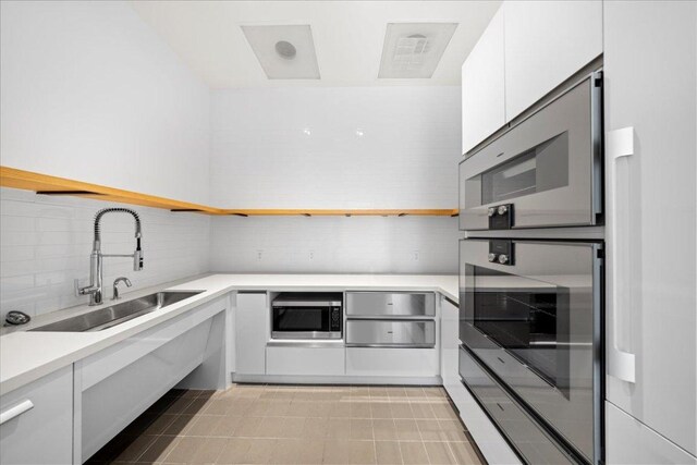 313 W 17th St Unit 2403, Austin, TX 78701 - kitchen with white cabinets, open shelves, modern cabinets, a sink, and decorative backsplash