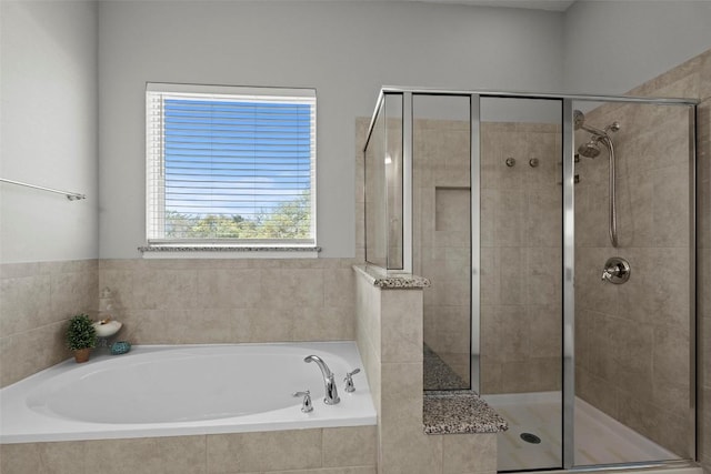 full bathroom featuring a shower stall and a garden tub