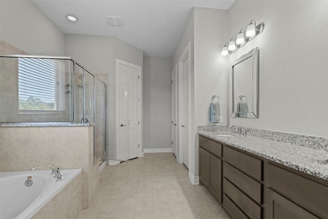full bath with a bath, a shower stall, double vanity, and baseboards