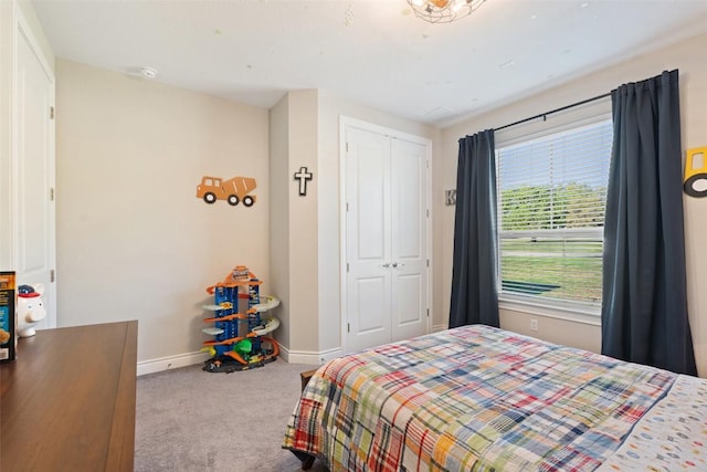 carpeted bedroom with baseboards and a closet