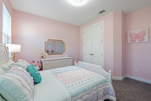 carpeted bedroom featuring baseboards and a closet