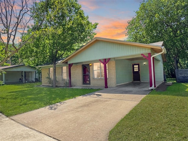 5306 Wellington Dr, Austin, TX 78723 - view of front facade featuring driveway, a yard, a carport, and brick siding