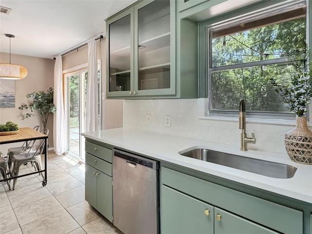 5306 Wellington Dr, Austin, TX 78723 - kitchen with stainless steel dishwasher, green cabinetry, a sink, and backsplash