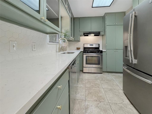 5306 Wellington Dr, Austin, TX 78723 - kitchen with appliances with stainless steel finishes, green cabinets, a sink, light countertops, and under cabinet range hood