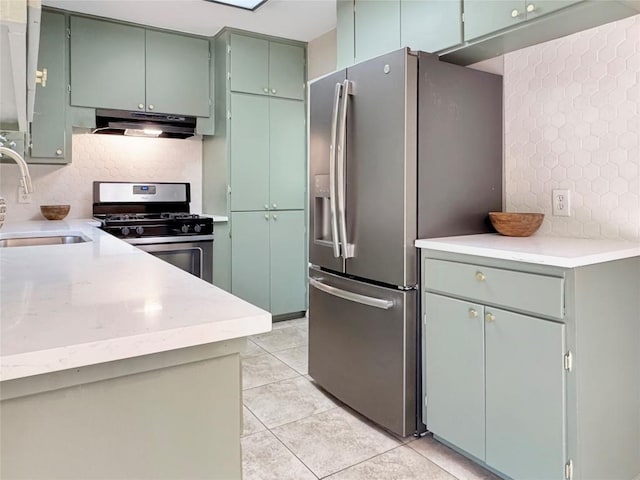 5306 Wellington Dr, Austin, TX 78723 - kitchen featuring stainless steel appliances, under cabinet range hood, light countertops, and light tile patterned floors
