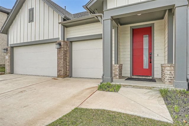 650 Texas Sage Loop, Buda, TX 78610 - property entrance featuring board and batten siding, a shingled roof, a garage, and concrete driveway