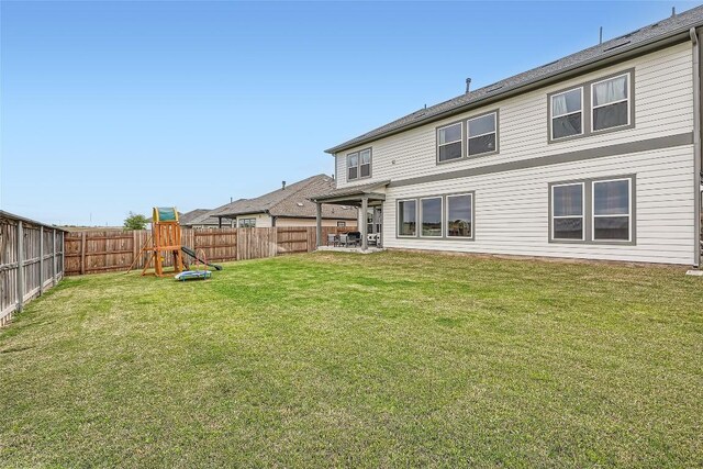 650 Texas Sage Loop, Buda, TX 78610 - back of property with a fenced backyard, a playground, and a lawn