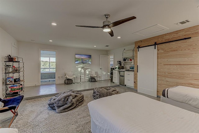 bedroom featuring baseboards, a barn door, recessed lighting, wooden walls, and fridge