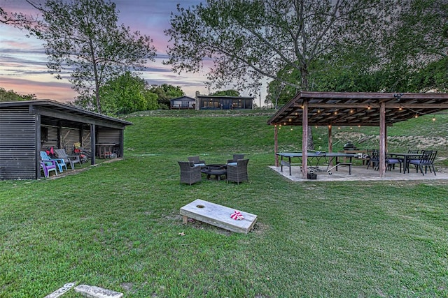 view of green lawn with a fire pit, a patio area, and a gazebo