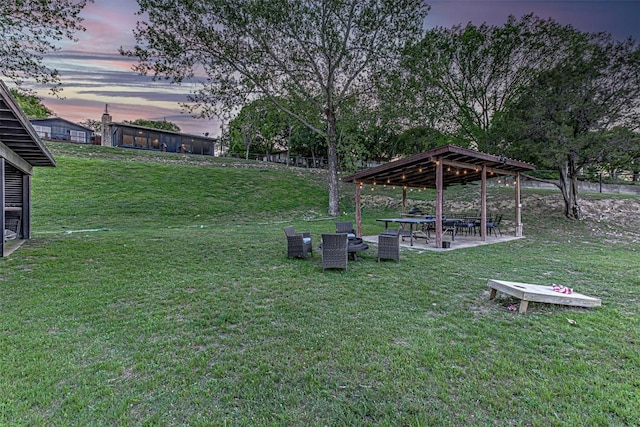 yard at dusk featuring a lawn and a gazebo