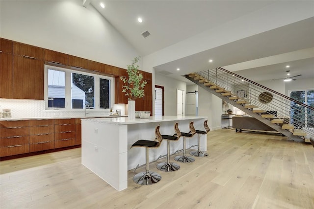 5001 Shoal Creek Blvd, Austin, TX 78756 - kitchen featuring modern cabinets, high vaulted ceiling, light wood finished floors, tasteful backsplash, and light countertops