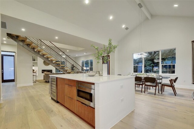 5001 Shoal Creek Blvd, Austin, TX 78756 - kitchen with modern cabinets, wine cooler, stainless steel microwave, beam ceiling, and a spacious island