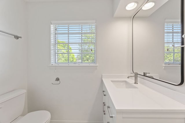 8014 Stillwood Ln, Austin, TX 78757 - half bathroom with toilet, baseboards, vanity, and plenty of natural light