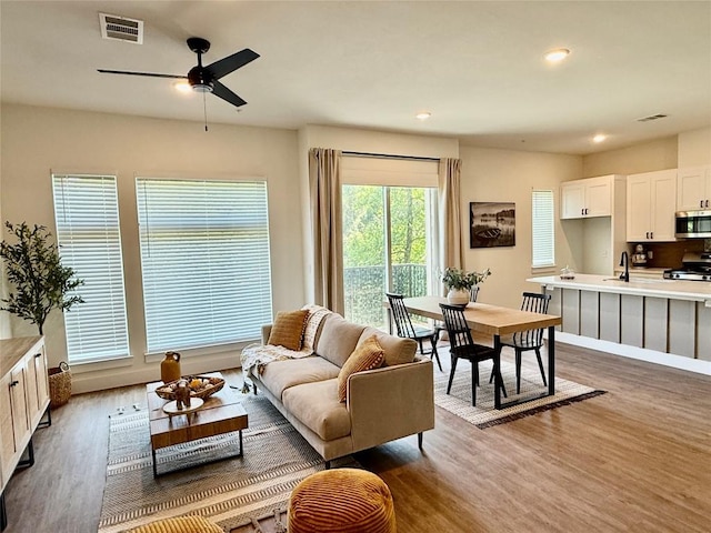 1811 Webberville Rd Unit 1206, Austin, TX 78721 - living area with wood finished floors, ceiling fan, recessed lighting, and baseboards