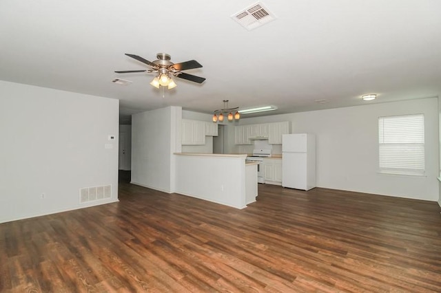 13604 Sierra Wind Ln, Elgin, TX 78621 - unfurnished living room featuring ceiling fan, dark wood finished floors, and a chandelier