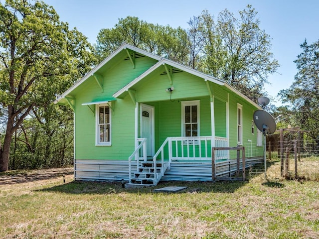 bungalow with a porch and a front lawn
