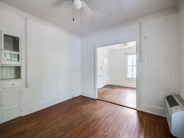 spare room featuring dark wood-type flooring, baseboards, ornamental molding, and ceiling fan