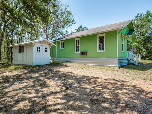 back of property with a shed, an outdoor structure, and board and batten siding