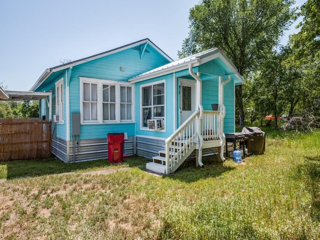 rear view of property with cooling unit, fence, and a lawn