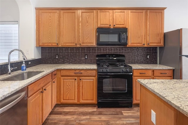 2025 Wayward Sun Dr, Austin, TX 78754 - kitchen featuring black appliances, dark wood finished floors, light stone countertops, and backsplash