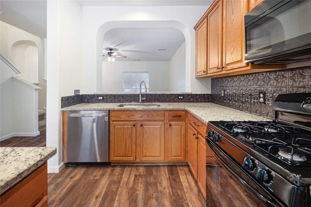 2025 Wayward Sun Dr, Austin, TX 78754 - kitchen featuring black appliances, arched walkways, a ceiling fan, light stone countertops, and dark wood-style flooring