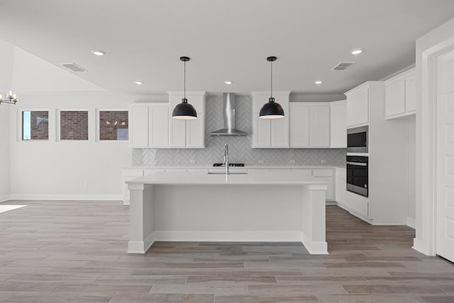kitchen featuring visible vents, light countertops, oven, and wall chimney exhaust hood