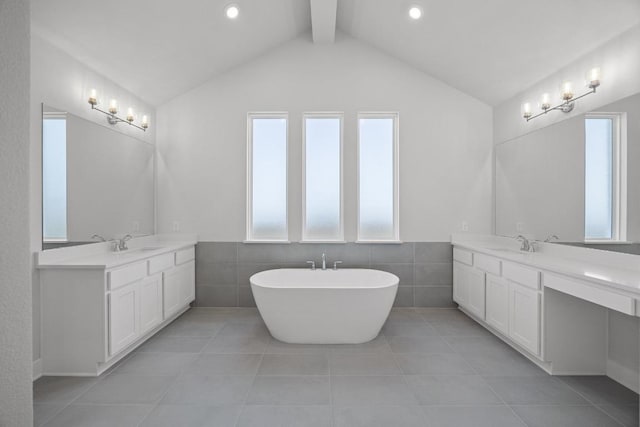 bathroom featuring tile patterned floors, lofted ceiling with beams, two vanities, and a sink