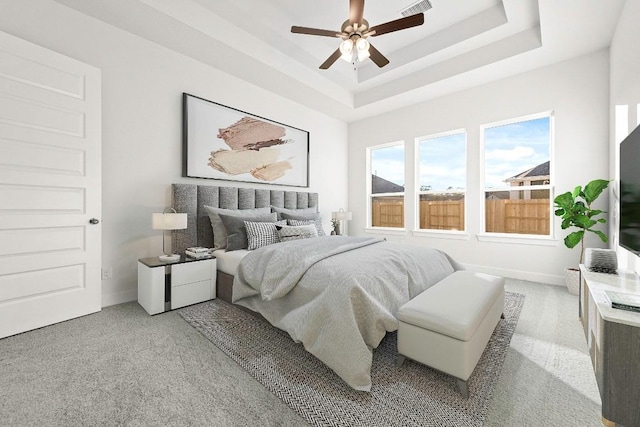 212 Ranchland Pass, Liberty Hill, TX 78642 - bedroom featuring light carpet, a tray ceiling, a ceiling fan, and baseboards