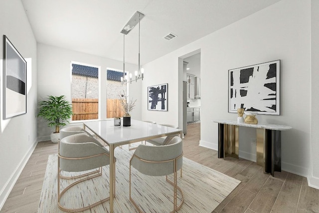 212 Ranchland Pass, Liberty Hill, TX 78642 - dining room featuring light wood-type flooring, baseboards, and a chandelier
