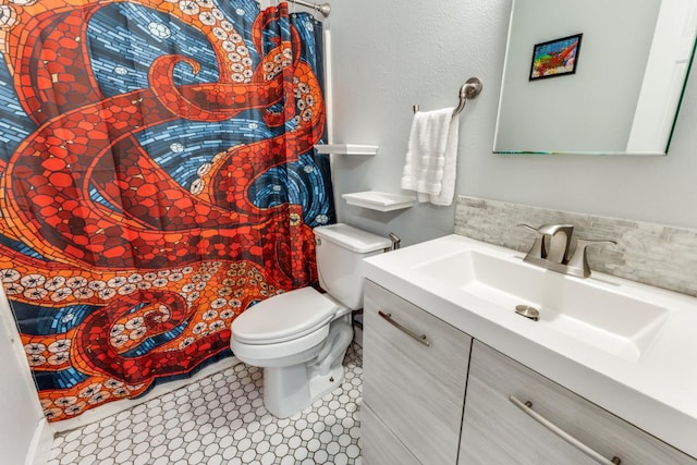 6309 Woodhue Dr, Austin, TX 78745 - bathroom with toilet, vanity, tile patterned floors, and backsplash
