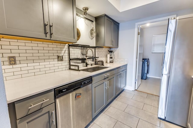 6309 Woodhue Dr, Austin, TX 78745 - kitchen featuring appliances with stainless steel finishes, gray cabinetry, a sink, and light tile patterned flooring
