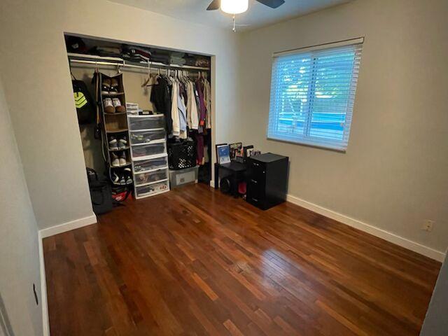 6309 Woodhue Dr, Austin, TX 78745 - bedroom with wood finished floors, baseboards, a closet, and ceiling fan