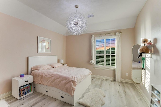 bedroom with visible vents, baseboards, wood finished floors, and a chandelier
