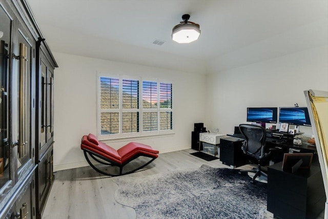 office area featuring baseboards, visible vents, and wood finished floors